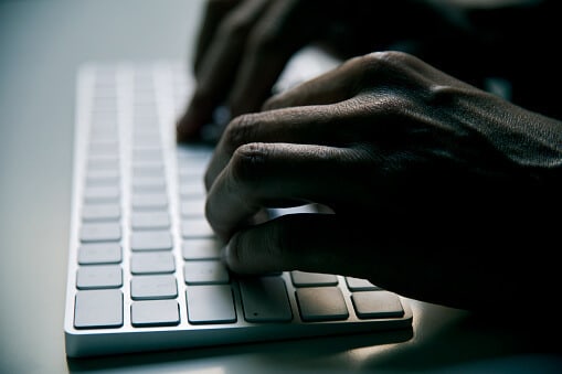 young man typing in a computer keyboard